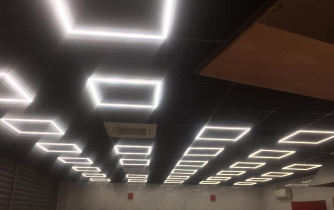 Plafond noir à cadres LED lumineux dans un local commercial