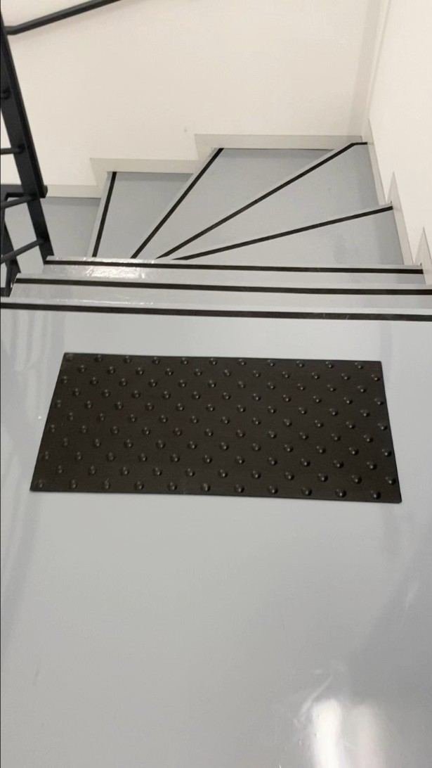 Palier d'escalier en résine grise avec bande podotactile